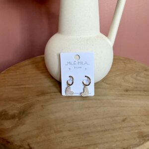 "Boucles d'oreilles créoles dorées en acier inoxydable avec pendentif cœur pavé de strass scintillants, présentées par Milë Mila sur un support en bois."