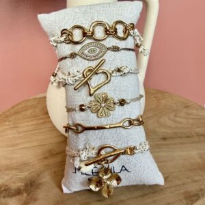 Sélection de bracelets cordons Mile Mila : motifs œil, cœur, trèfle et maillons dorés sur cordons beiges et blancs.