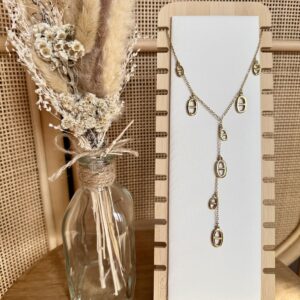 Collier doré style chapelet avec breloques maillons ovales suspendus sur une chaîne fine.