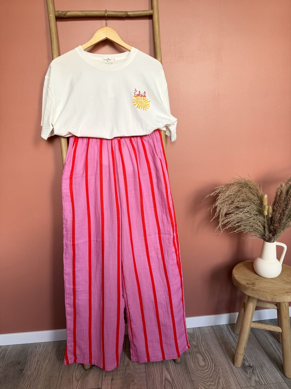 T-shirt blanc graphique "le soleil" associé à un pantalon rayé rose rouge