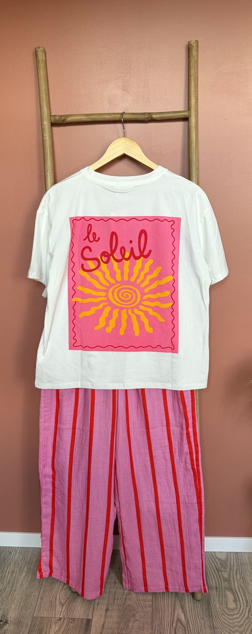 T-shirt blanc graphique "le soleil" associé à un pantalon rayé rose rouge